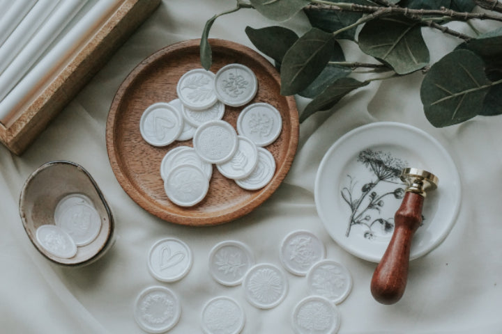 multiple_designs-wax_seals_in_a_bowl-Dove_white-floral_accents-wax_stamp-botanical_accents-background_2 - Made of Honour Co.16184552193b4706ec-2
