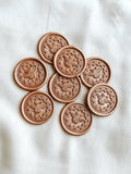 bee wax seals in Champagne rose colour with cloth in the background.