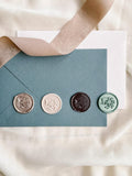 Butterfly wax seals in multiple colours colour with cloth and envelope in the background.