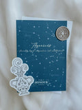 Aquarius aquamarine greeting card back with sticker and Antique gold matching wax seal with envelope and cloth in the background.