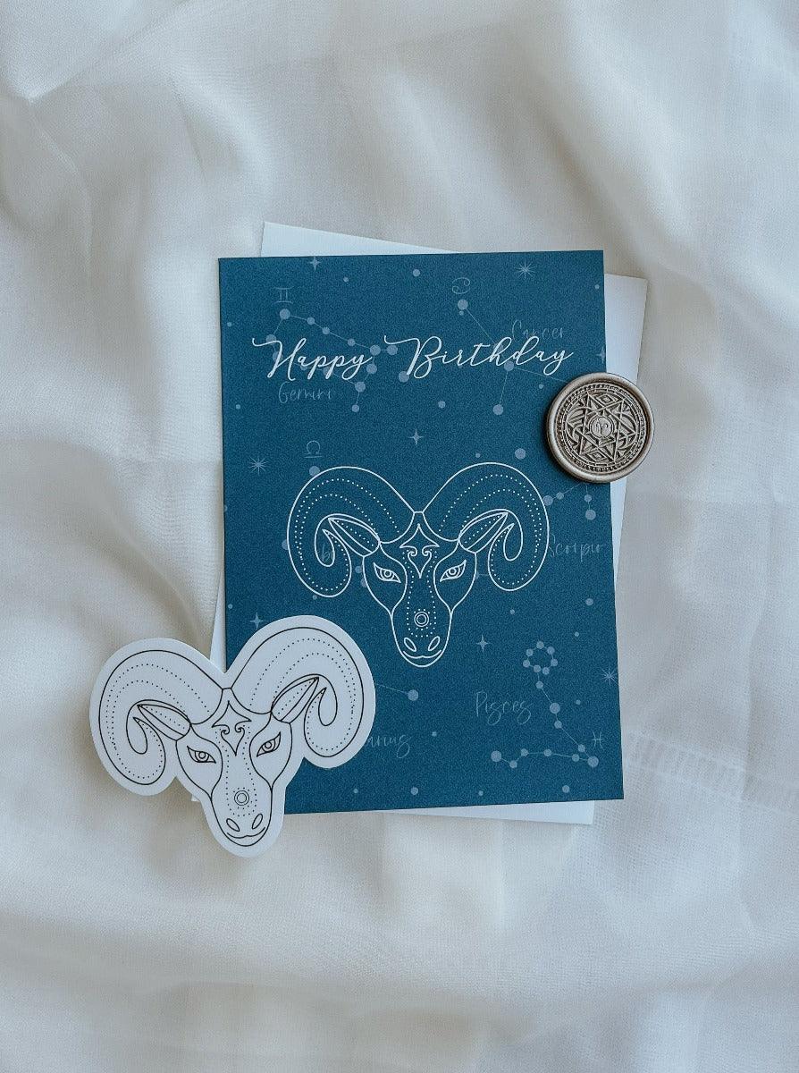 Aries greeting card in Aquamarine colour with antique gold wax seal and envelope and matching sticker in the background.