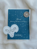 Back of Aries greeting card in Aquamarine colour with antique gold wax seal and envelope and matching sticker in the background.
