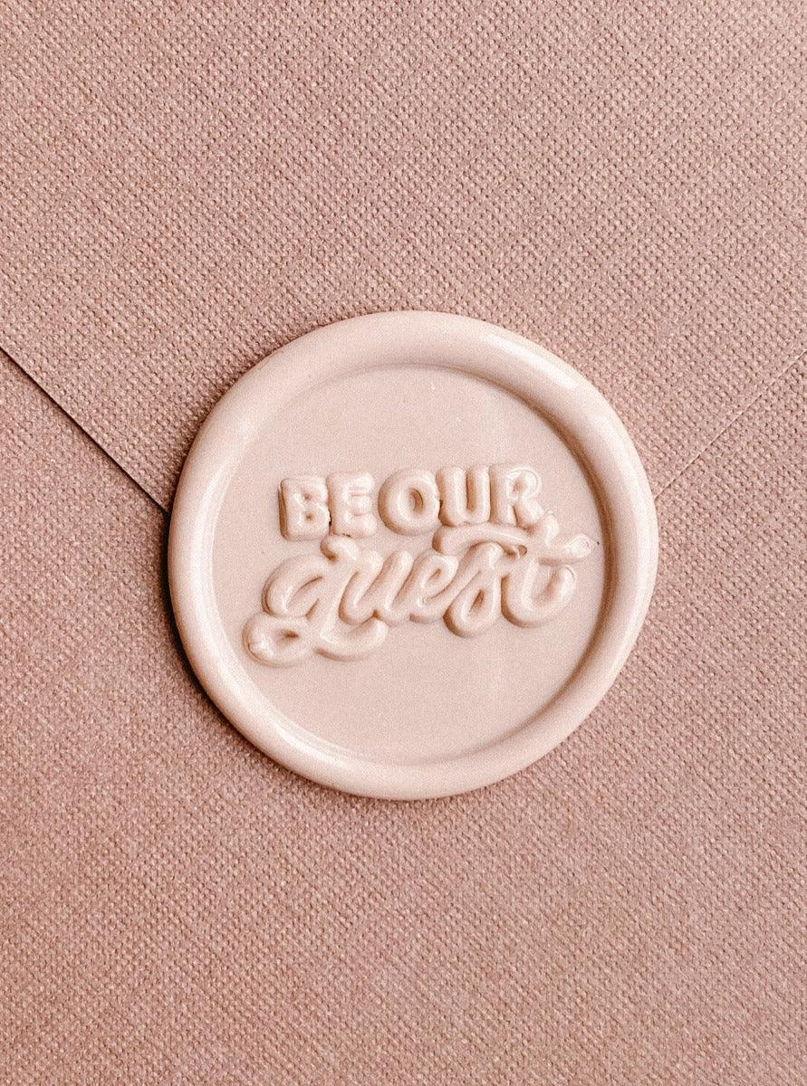 be our guest wax seal in Neutral Taupe colour with envelope in the background.