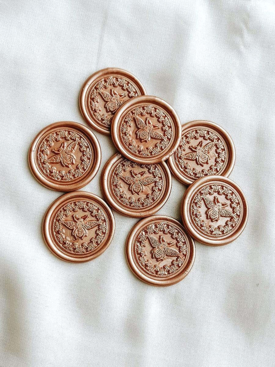 bee wax seals in Champagne rose colour with cloth in the background.